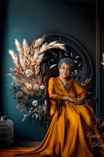 old woman poses sitting on a chair in a studio wearing a long cognac color dress made of silk.